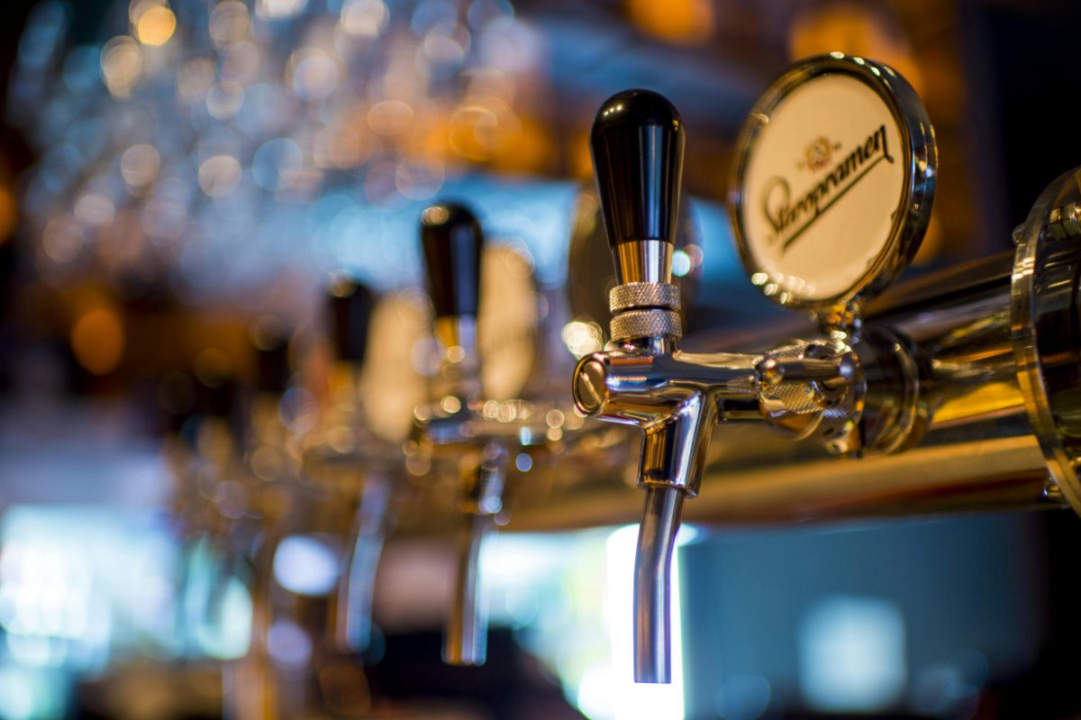 Polished taps and glassware behind a bar